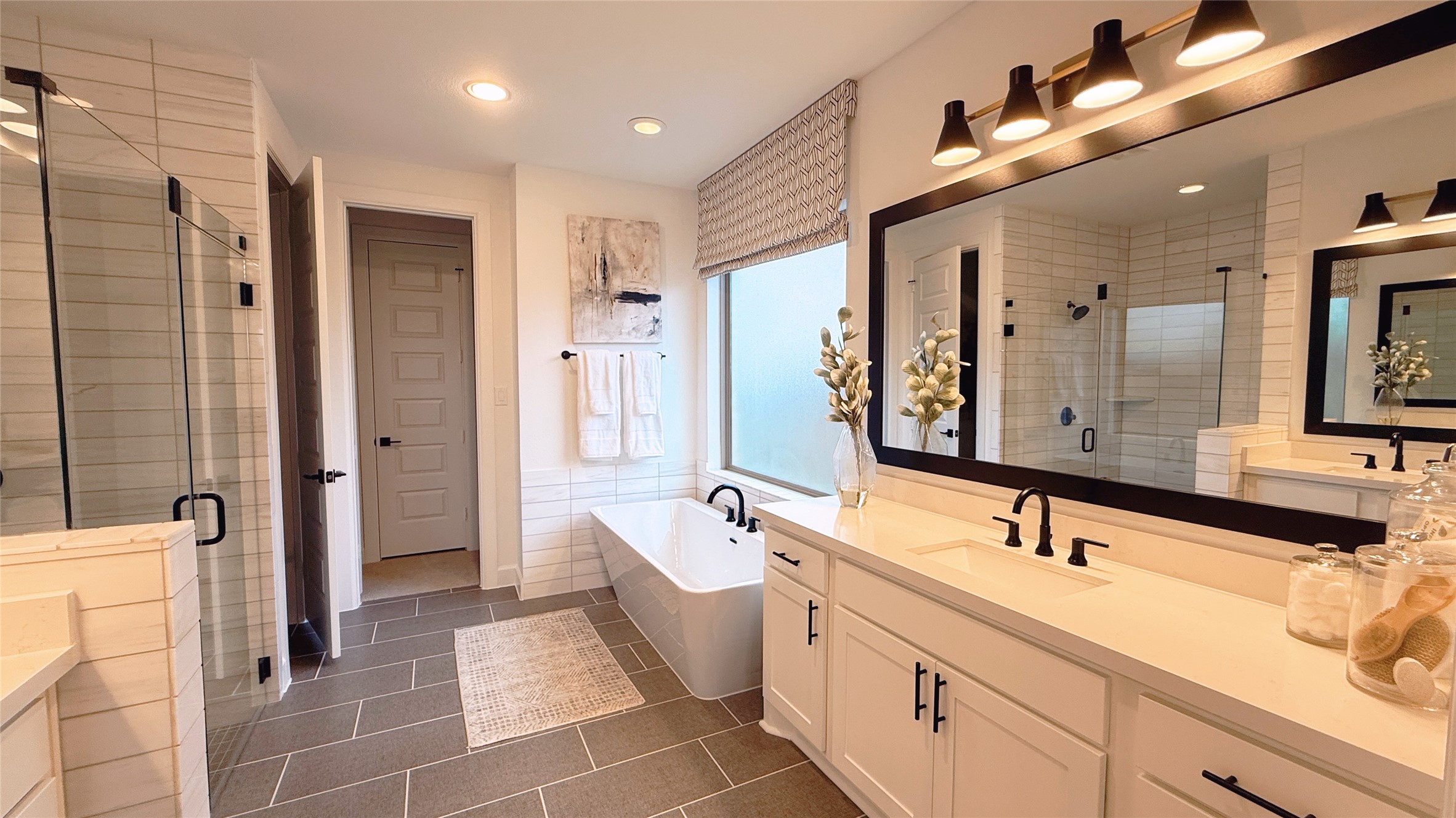 5603 Logan Ridge Lane Fulshear, TX 77441 - Photo 23 of 43 a spacious bathroom with a double vanity sink a large mirror and a bathtub
