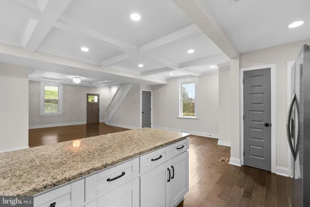 a kitchen with granite countertop a sink and a refrigerator