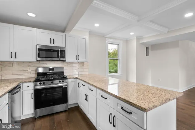 a kitchen with stainless steel appliances granite countertop a stove a sink and a microwave