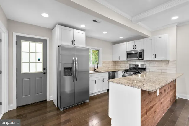a kitchen with a refrigerator a sink a stove a microwave and cabinets