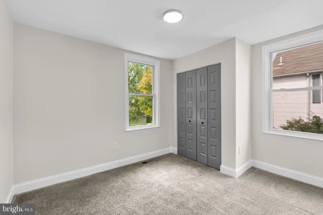 an empty room with windows and closet