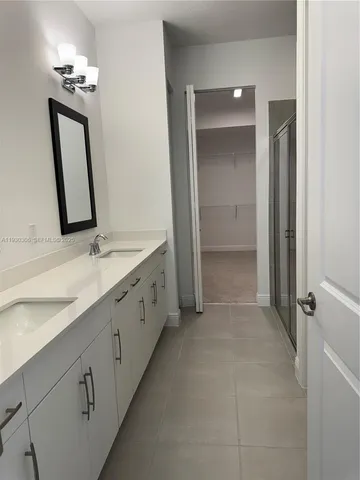 a spacious bathroom with a double vanity sink and a mirror