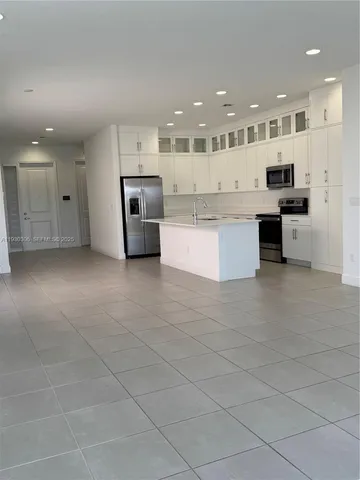 a large kitchen with stainless steel appliances kitchen island granite countertop a large counter top and stainless steel appliances
