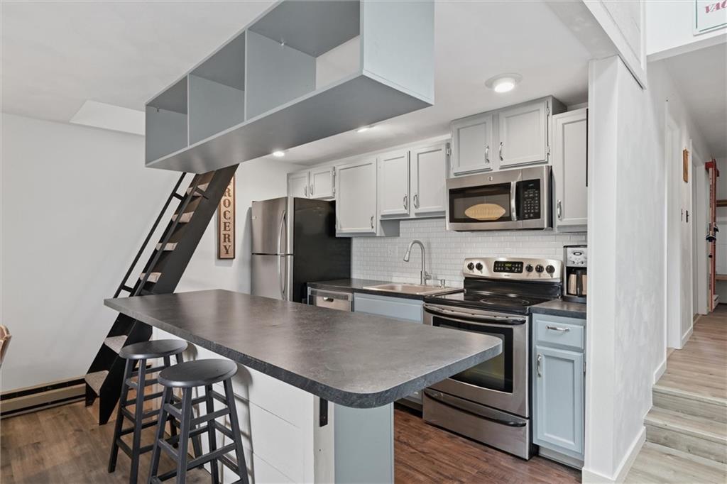 580 Maple Court Hidden Valley, PA 15502 - Photo 4 of 28 a kitchen with stainless steel appliances a stove a sink a microwave and cabinets