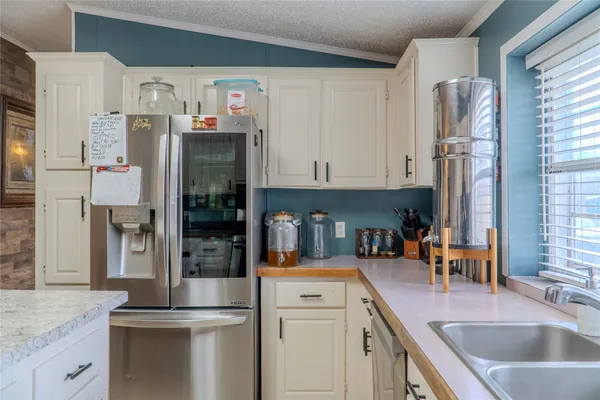 a kitchen with stainless steel appliances granite countertop a refrigerator and a sink