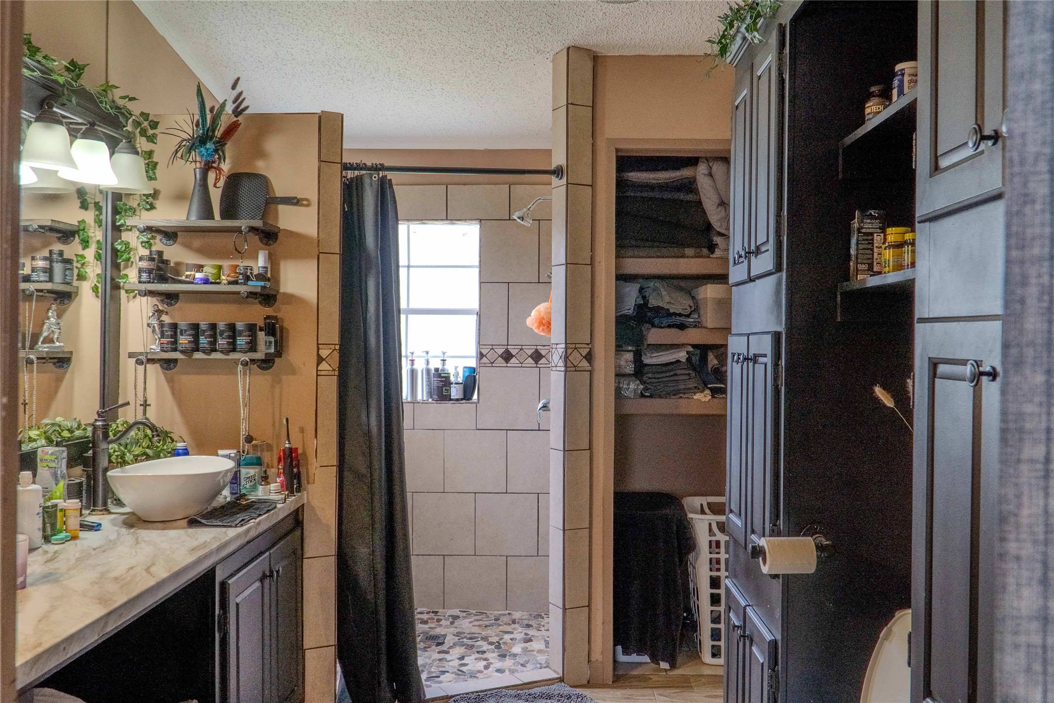 7519 Silvermine Road Harwood, TX 78632 - Photo 14 of 20 a bathroom with a granite countertop sink a mirror and shower