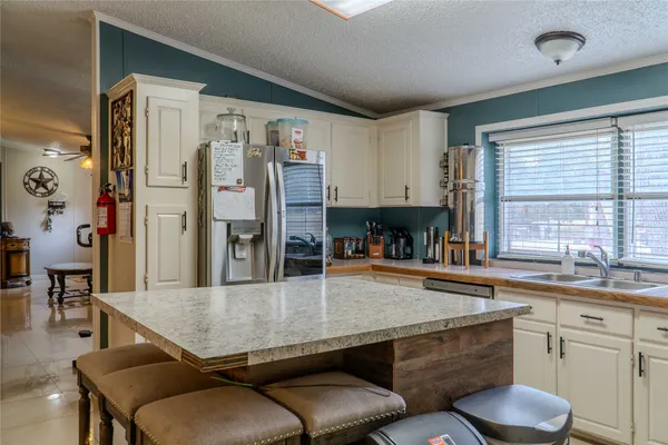 a kitchen with a table chairs sink and refrigerator