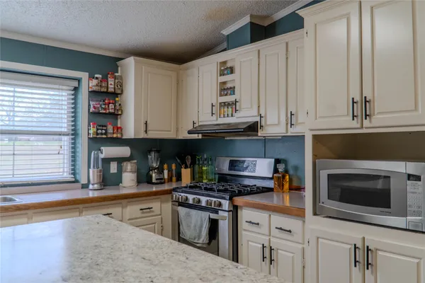 a kitchen with stainless steel appliances granite countertop a stove and a microwave