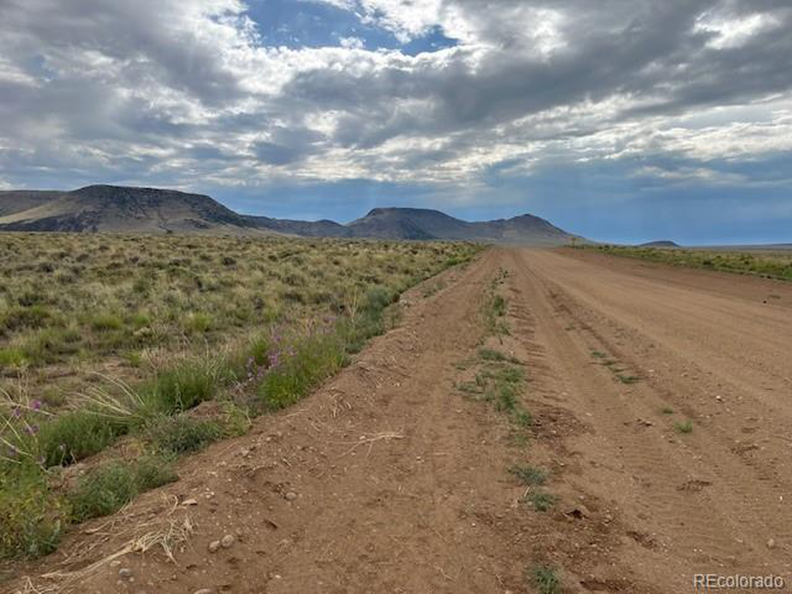 35 Co Road San Luis, CO 81152 - Photo 2 of 8 a view of a dry yard with mountains in the background