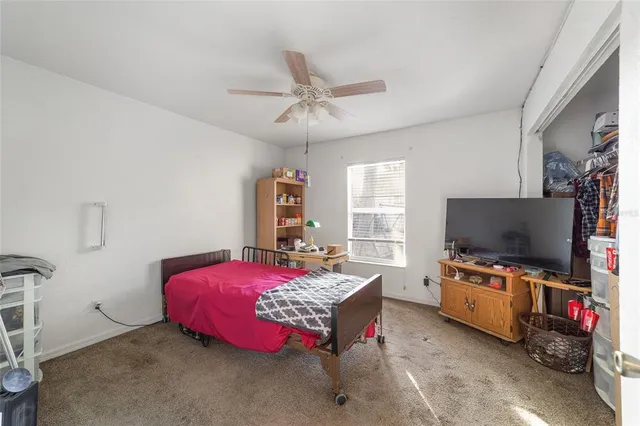a bedroom with a bed and a flat tv screen on the dresser