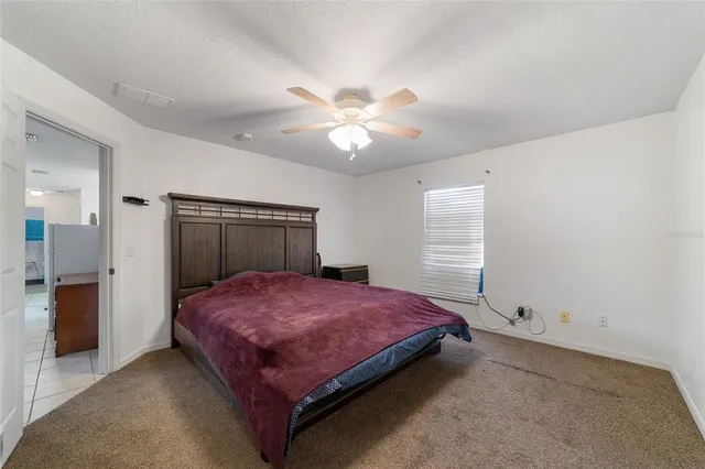 a bedroom with a bed and a ceiling fan