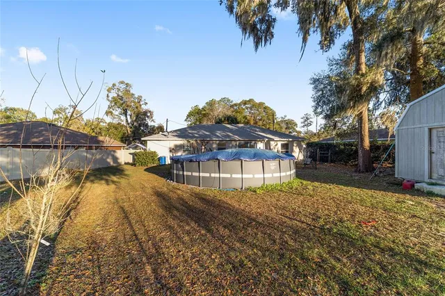 a view of yard with swimming pool and trees