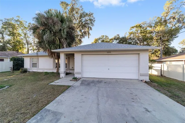 a view of a house with a yard and a garage