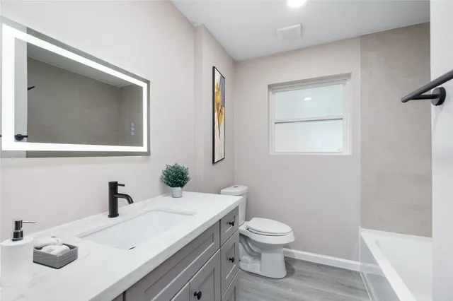 a bathroom with a toilet sink and mirror