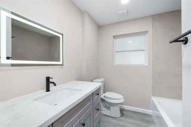 a bathroom with a toilet a sink and mirror