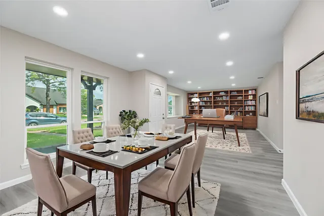 a view of a dining room and livingroom with furniture window and wooden floor
