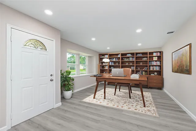 a view of a workspace with furniture and a window