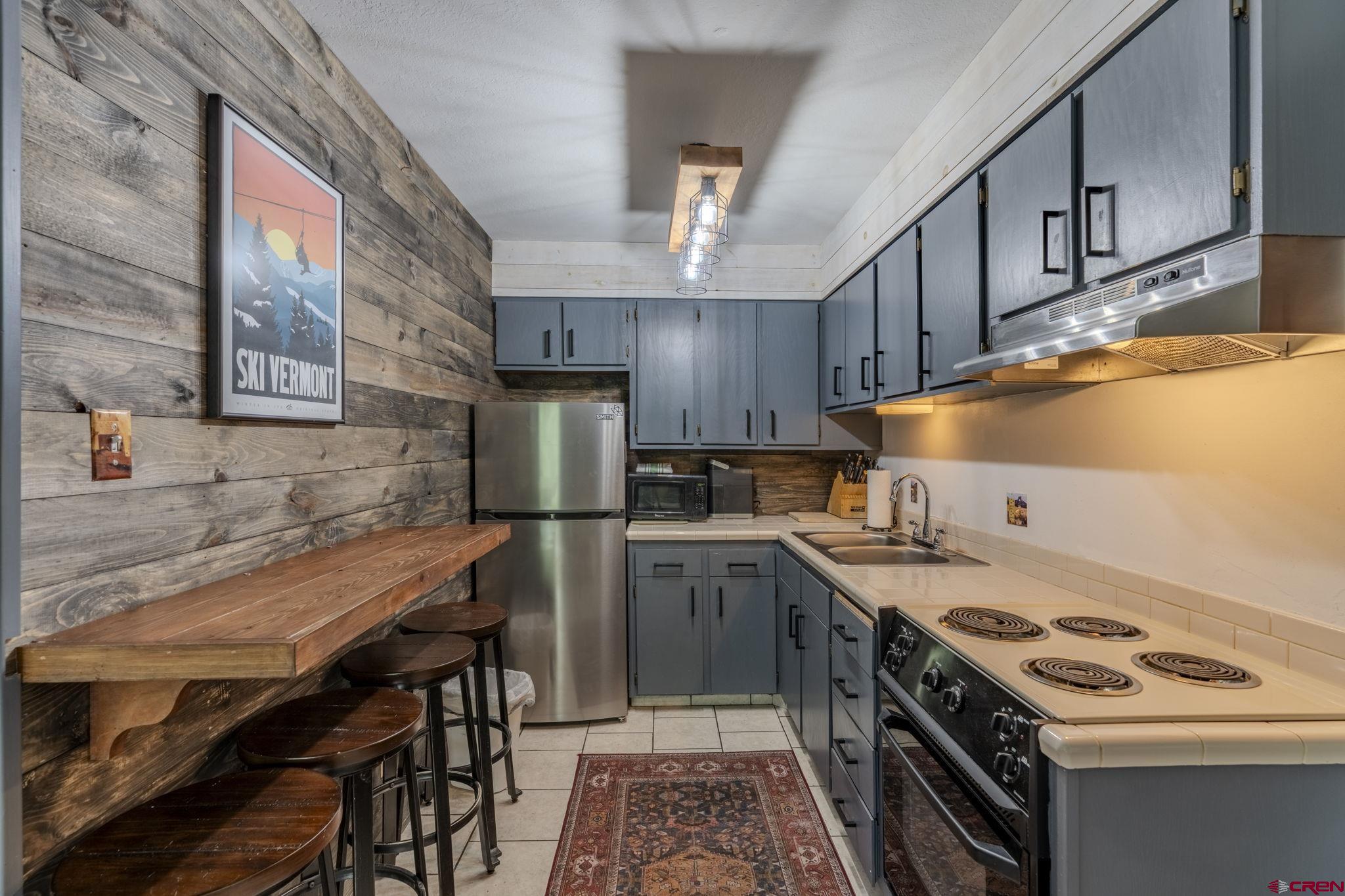 395 Sheol Street, Unit 109 Durango, CO 81301 - Photo 11 of 30 a kitchen with a stove a sink and a refrigerator