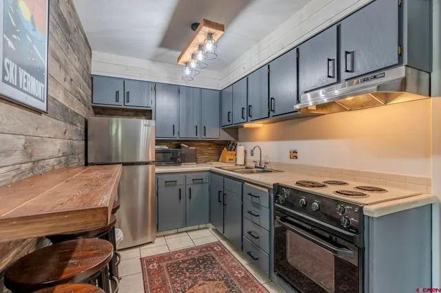 a kitchen with a stove a sink and cabinets