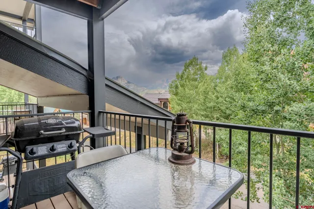 a view of a balcony with wooden floor table and chairs
