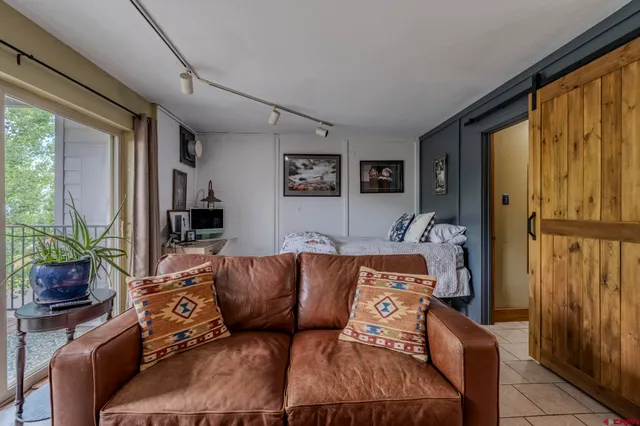 a blue couch sitting in a living room next to a window