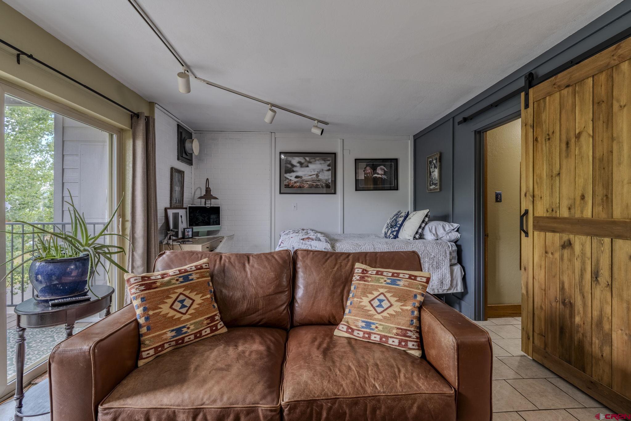 395 Sheol Street, Unit 109 Durango, CO 81301 - Photo 4 of 30 a blue couch sitting in a living room next to a window