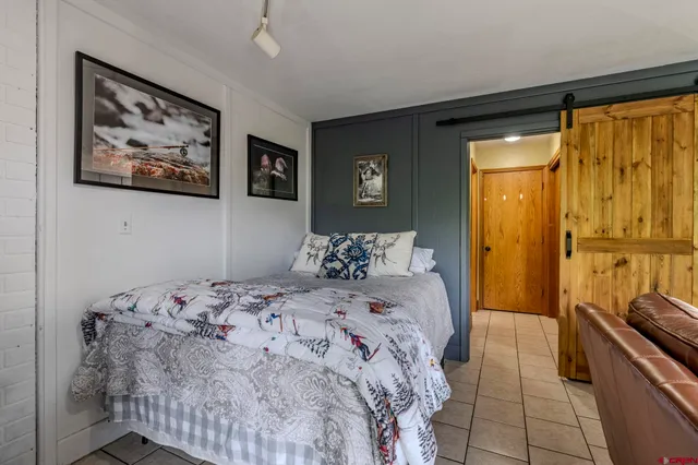 a bedroom with a bed and a painting on the wall