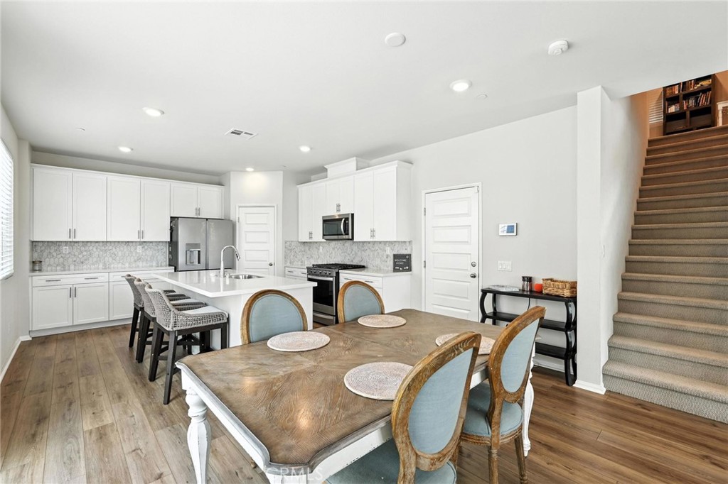 28267 Ashtree Street Temecula, CA 92591 - Photo 13 of 41 a view of a dining room with furniture and wooden floor