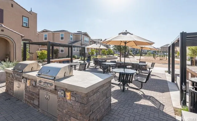 a view of a patio with couches table and chairs under an umbrella