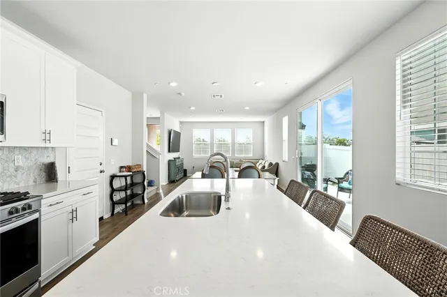 a large white kitchen with lots of counter space a sink and appliances