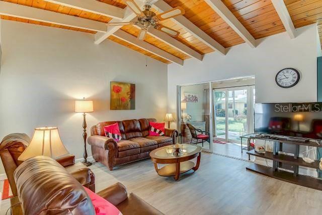 6006 Midnight Pass Road, Unit 24 Sarasota, FL 34242 - Photo 2 of 16 a living room with furniture and a flat screen tv