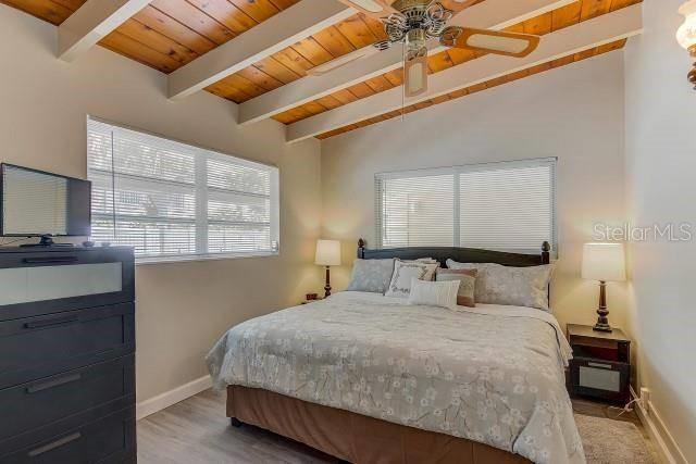 6006 Midnight Pass Road, Unit 24 Sarasota, FL 34242 - Photo 6 of 16 a bedroom with a bed a dresser with mirror and window