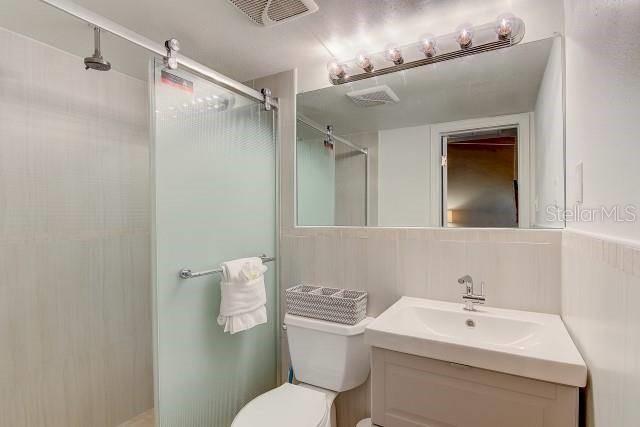 6006 Midnight Pass Road, Unit 24 Sarasota, FL 34242 - Photo 7 of 16 a bathroom with a toilet sink and mirror