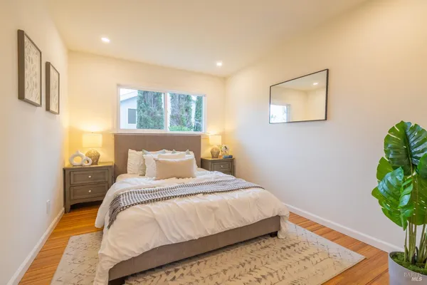 a bedroom with a bed potted plant and a window