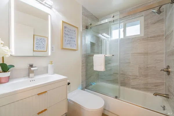 a bathroom with a sink toilet a mirror and shower