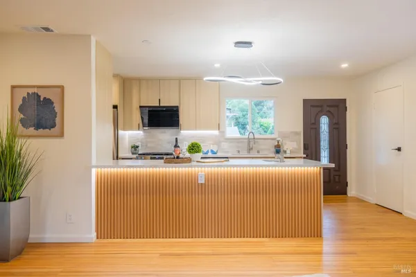 a view of kitchen with stainless steel appliances granite countertop a stove a sink and a refrigerator