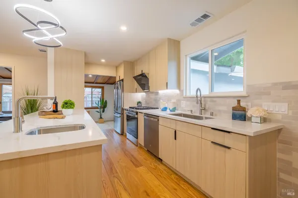 a large kitchen with kitchen island a sink stainless steel appliances and cabinets