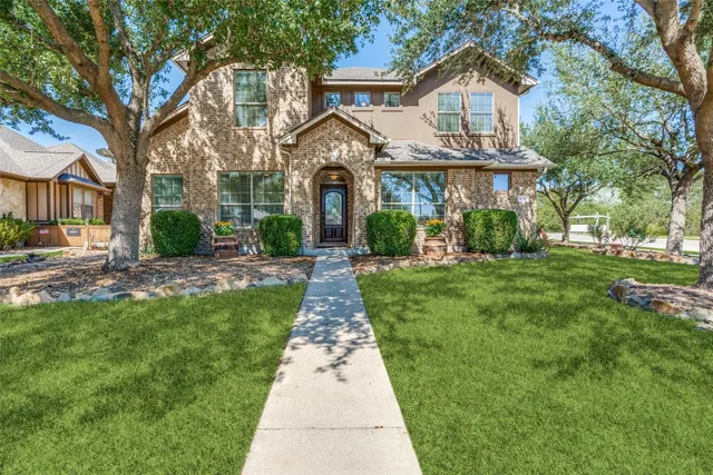 a front view of a house with a yard and potted plants