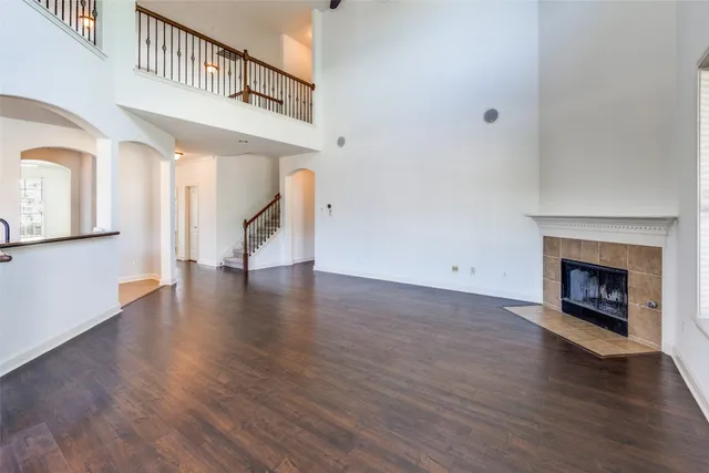 a view of a livingroom with wooden floor and a kitchen
