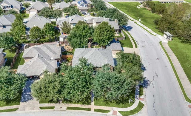an aerial view of a house with a yard and lake view
