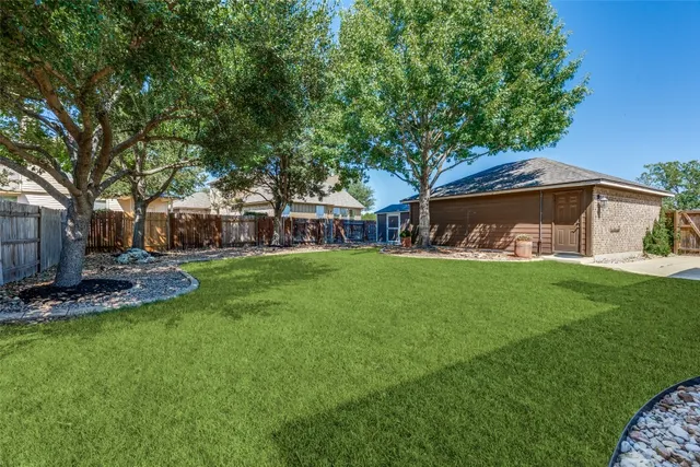 a view of a house with backyard and sitting area