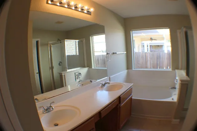 a bathroom with a tub sink and mirror
