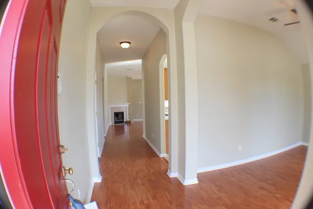 a view of a hallway with wooden floor and staircase