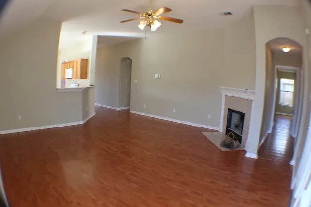 a view of a livingroom with wooden floor and a ceiling fan