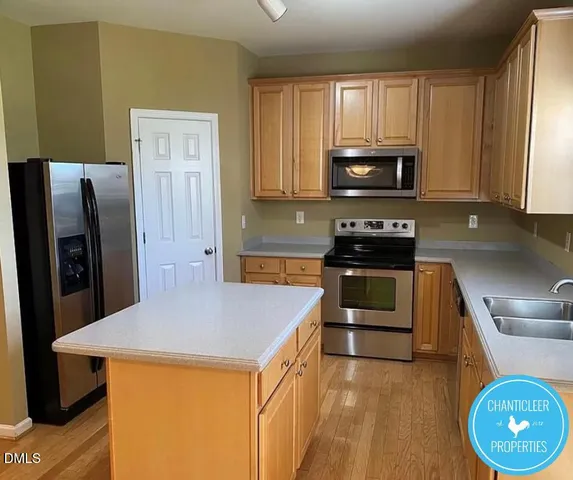 a kitchen with a refrigerator a stove a microwave a sink and cabinets