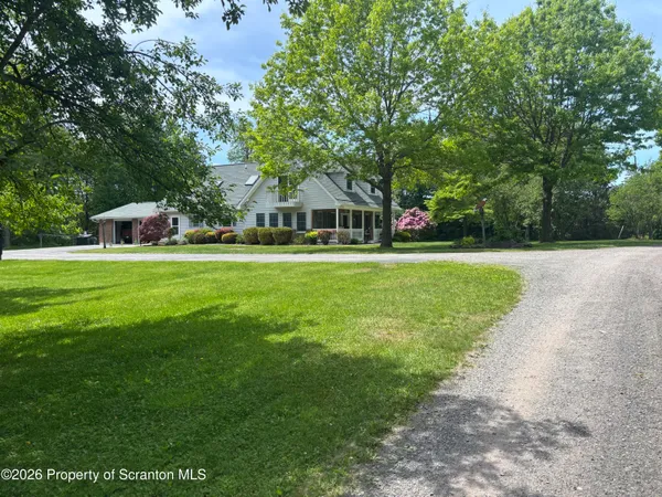 a front view of a house with a yard and trees