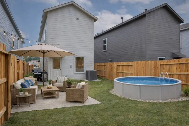 a view of a house with backyard and sitting area