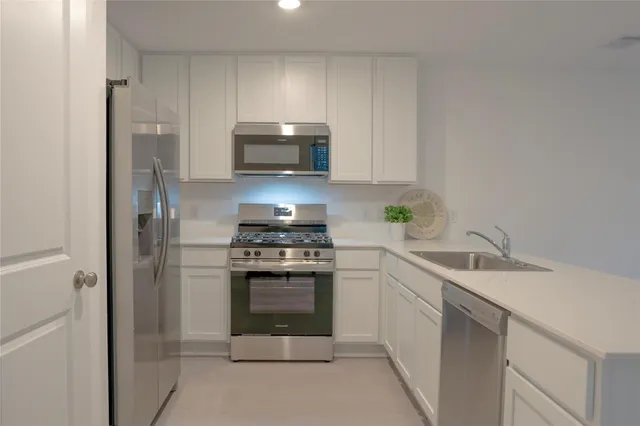 a kitchen with stainless steel appliances a stove sink and refrigerator