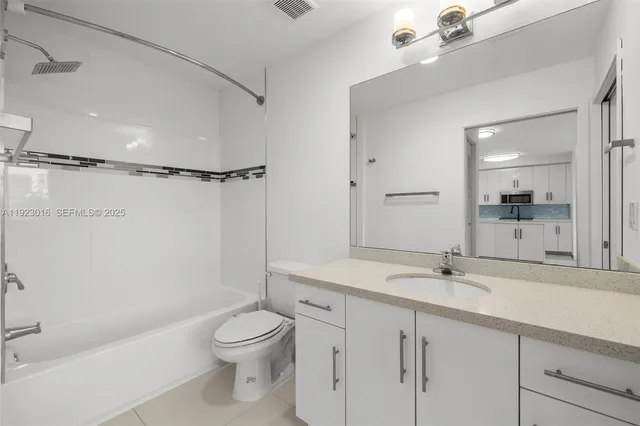 a bathroom with a granite countertop toilet a sink and a mirror