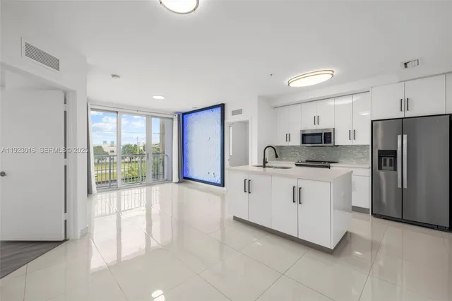 a kitchen with white cabinets and refrigerator